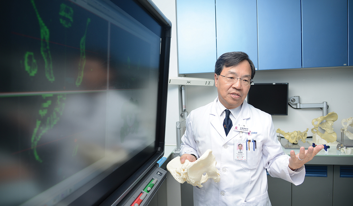 Doctor holding 3d printed bones near computer screen